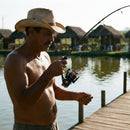Pescador brigando com um peixe usando o Molinete Daiwa Fuego LT